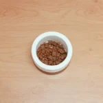 Собака їсть з миски високобілковий корм