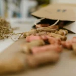 Святкові ласощі для собак висипані з паперового пакета на стіл серед декоративної соломки